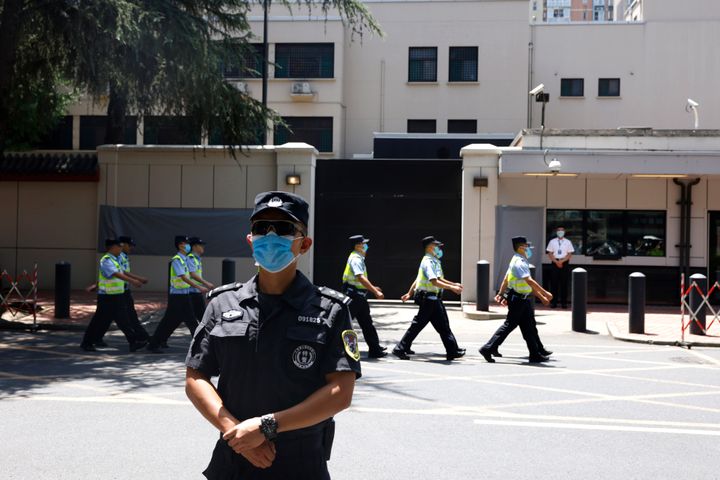 Chinese police officers march past the former U.S. Consulate in Chengdu on Monday.