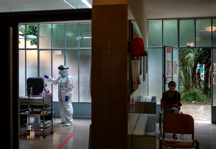 Una profesional sanitaria realiza una prueba PCR a un paciente.