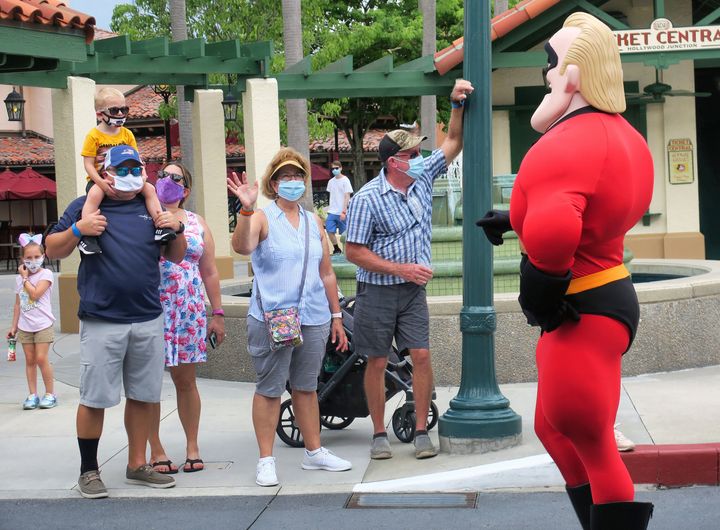 Guests wave to Mr. Incredible during a pop-up appearance of Pixar characters at Disney's Hollywood Studios at Walt Disney World on July 16, the second day of the park's reopening, in Lake Buena Vista, Florida.