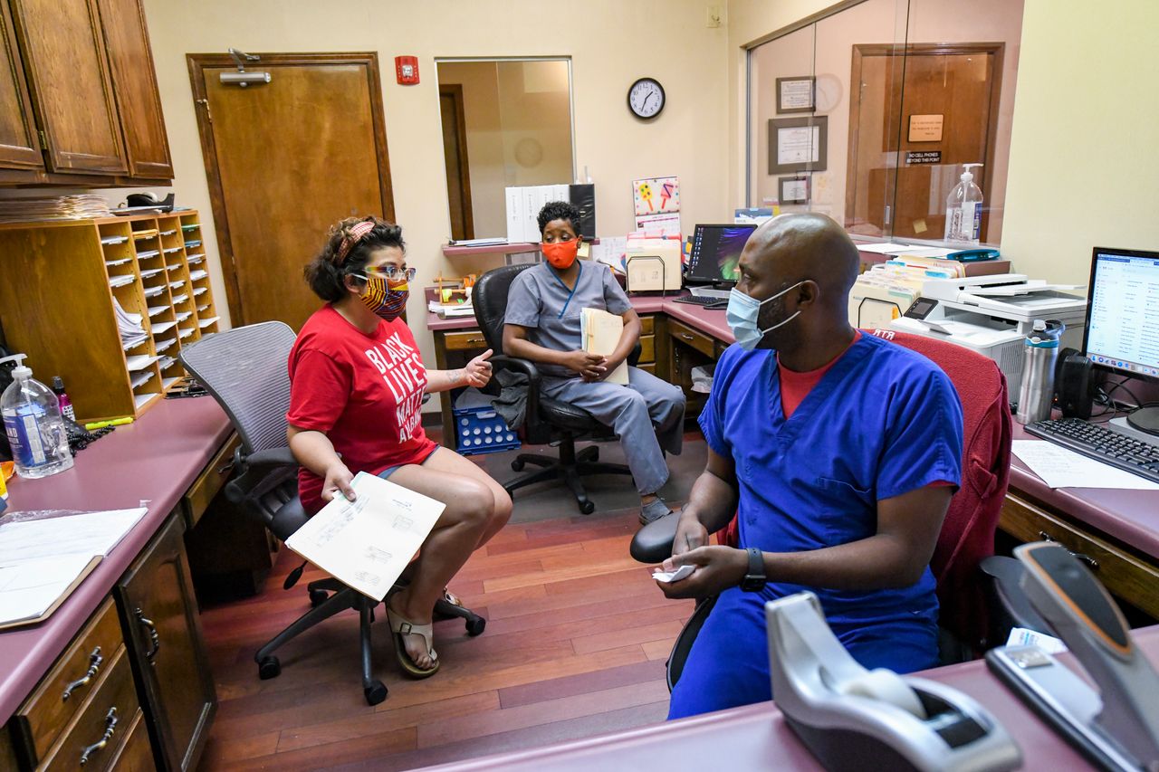 Amanda Reyes, center, talks with medical team manager Alesia Horton, left, and office manager Chadric Jackson in the front office at the West Alabama Women's Center on June 5 in Tuscaloosa.