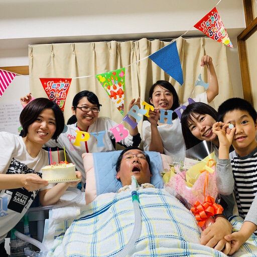 家族や訪問介護のスタッフらと49歳の誕生日を祝う太田守武さん（中央）
