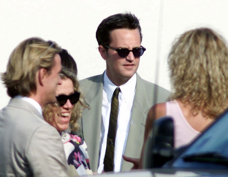 Matthew Perry talks with unidentified guests at the oceanside wedding of Brad Pitt and Jennifer Aniston in Malibu, Calif., Saturday, July 29, 2000