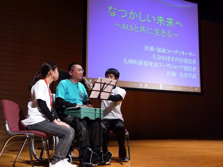医師、ALS患者の立場で講演する太田さん（中央）（2016年撮影）