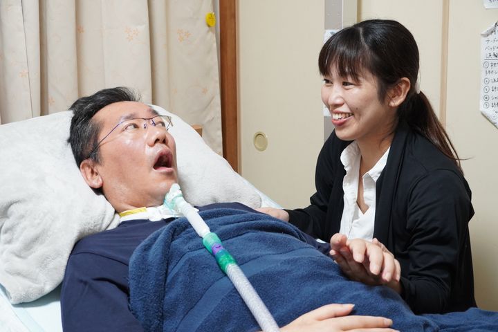 太田守武さん（左）と妻の友香利さん。守武さんが開発した、眼球の動きと瞬きで文字を伝える「ダブルクロストーク」の手法でコミュニケーションを取っている