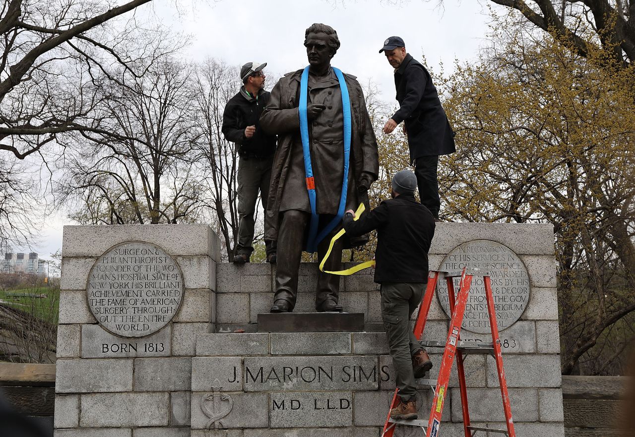 Parks Department workers place a harness over a statue of James Marion Sims before it is taken down from its pedestal at Central Park and East 103rd Street on April 17, 2018 in New York City.