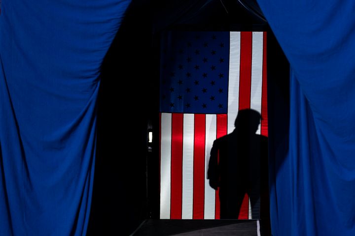The shadow of President Donald Trump falls on a flag during a Feb. 20 campaign rally in Colorado Springs, Colorado.