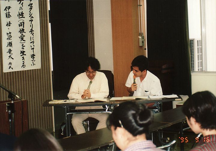講演中の伊藤悟さん（左）と簗瀬竜太さん。写真の下部に1995年と記されている。