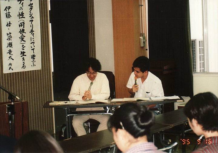 講演中の伊藤悟さん（左）と簗瀬竜太さん。写真の下部に1995年と記されている。