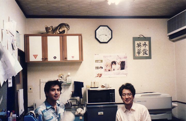 「すこたん企画」事務所での伊藤悟さん（右）と簗瀬竜太さん。1990年代後半の撮影。