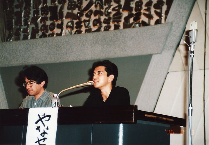講演活動をする伊藤悟さん（左）と簗瀬竜太さん。1990年代後半の撮影。