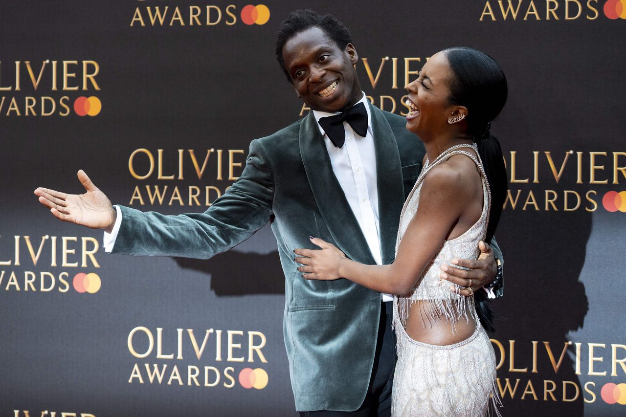 Kobna Holdbrook-Smith and US actress Adrienne Warren pose on the red carpet upon arrival to attend The Olivier Awards at the Royal Albert Hall in London