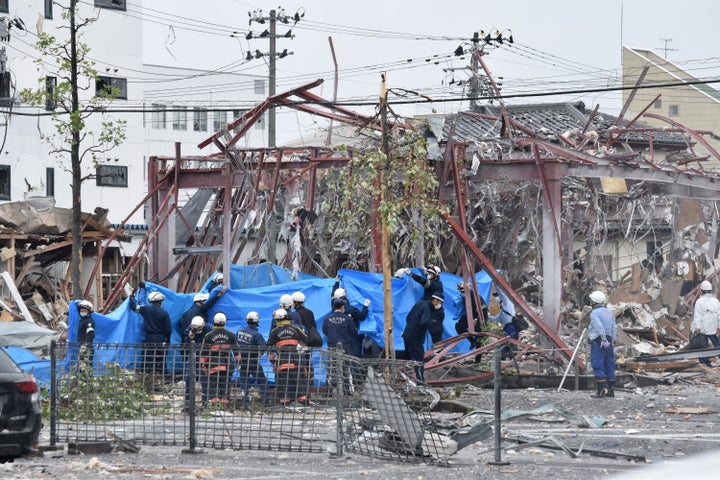 爆発事故が起きた飲食店「しゃぶしゃぶ温野菜郡山新さくら通り店」前で、ブルーシートを広げる消防隊員ら＝7月30日午前、福島県郡山市 