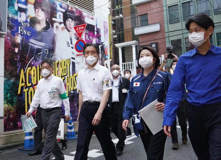 歌舞伎町のホストクラブなどに新型コロナウイルス対策を呼び掛けに回る新宿区の吉住健一区長（左から2人目）ら＝7月20日、東京都新宿区