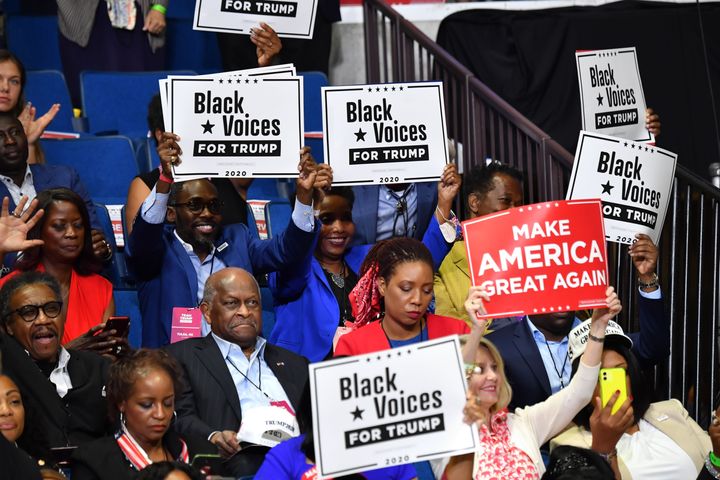 Herman Cain (C,L) and supporters of Donald Trump "Black Voices" listen to him speak during at the Tulsa rally.