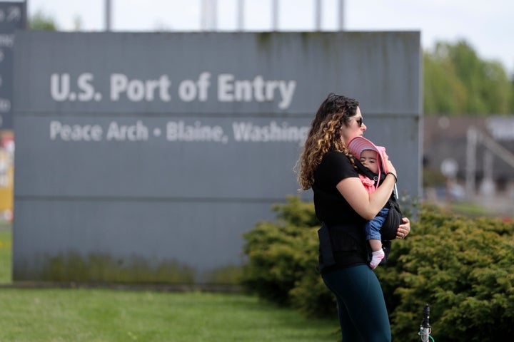 A woman and baby walk in Peace Arch Historical State Park in the U.S. on the border with Surrey, B.C., on May 17, 2020. This entry point into Canada will be closed to Americans headed to Alaska as of July 31, 2020 as officials enforce stricter rules to prevent the spread of COVID-19.