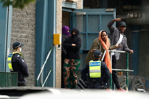 Residents talk with police officers at the Flemington Towers Government Housing complex on July 6 in...
