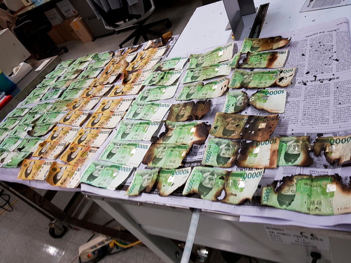 This undated photo provided by the Bank of Korea on Friday, July 31, 2020, shows damaged banknotes by being heated up in a mi