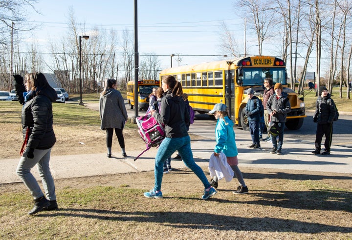 Parents and students meet teachers outside on May 11, 2020 at the Primerose school in Quebec City. 