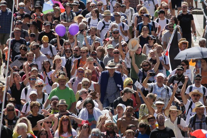 People mostly without face masks attend a demonstration with the slogan against coronavirus restrictions in Berlin, Germany, Saturday, Aug. 1, 2020.