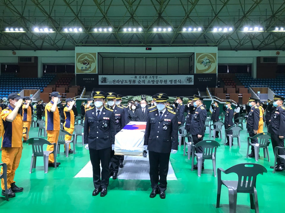 2일 오전 전남 순천시 팔마체육관에서 열린 고(故) 김국환 소방장의 영결식이 끝나자 운구 행렬이 동료 대원들의 경례를 받으며 영결식장을 나서고 있다