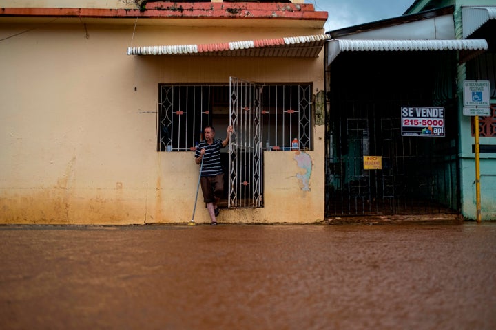 A man looks on from the front of his house after Tropical Storm Isaias affected the area in Mayaguez, Puerto Rico on July 30,