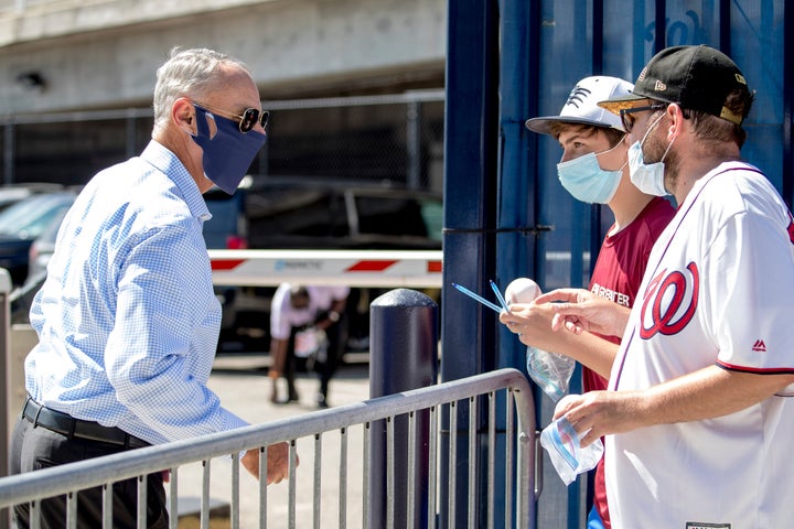 MLB Commissioner Rob Manfred, left, speaks with fans as he arrives at Nationals Park for the New York Yankees and the Washing