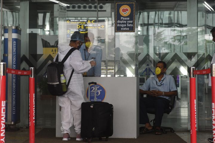 A passenger in PPE coveralls at the entrance gate of Netaji Subhas Chandra Bose International (NSCBI) Airport on July 23, 2020 in Kolkata.