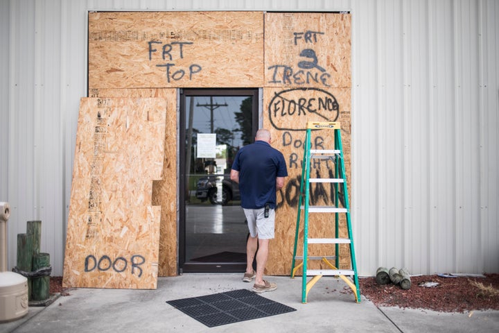 Terry Crabtree finishes boarding up the entrance to Downeast Marine in Otway, N.C. as Tropical Storm Isaias approaches on Mon
