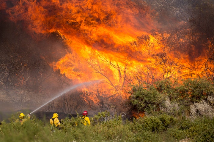 Firefighters battle the Apple Fire in Banning, Calif., on Sunday.