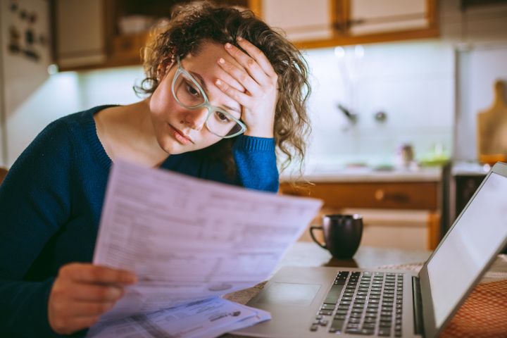 A woman reads over her credit card statements in this stock photo. A credit score above 680 is considered good for your financial health.