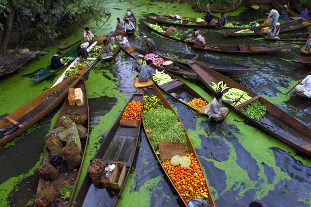 Kashmiri vegetable sellers gather at a floating market on Dal Lake in Srinagar, the summer capital of...