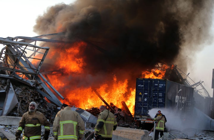 Lebanese firefighters extinguish fire at the scene of an explosion at the port in the capital Beirut.