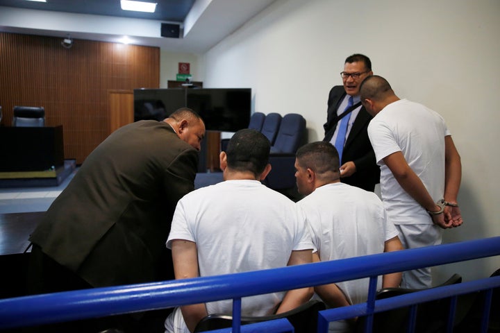 Three former El Salvador police officers, seen here conferring with their lawyers during their trial, were found guilty in la