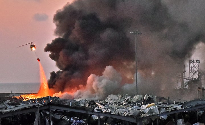 A helicopter puts out a fire Tuesday at the scene of an explosion at the port of Lebanon's capital, Beirut. 