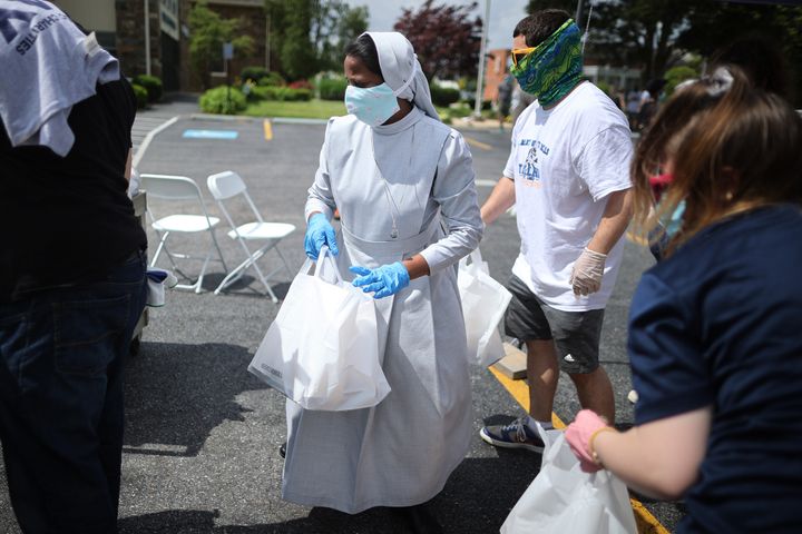 A nun helps distribute hot meals at one of the Catholic Charities of the Archdiocese of Washington's food distribution sites for those in need during the novel coronavirus pandemic on May 29 in Laurel, Maryland.