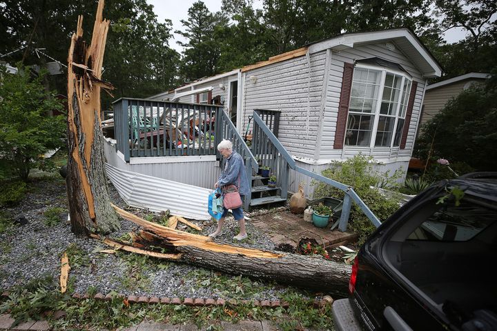 Ellen Mallen, who lives in a mobile home court, carefully leaves her home after a suspected tornado spawned by Isaias struck Marmora, N.J., Tuesday, Aug 4, 2020. (David Maialetti/The Philadelphia Inquirer via AP)