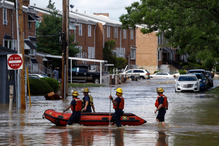 Philadelphia firefighters walk through a flooded neighborhood after Tropical Storm Isaias moved through, Tuesday, Aug. 4, 2020, in Philadelphia. (AP Photo/Matt Slocum)