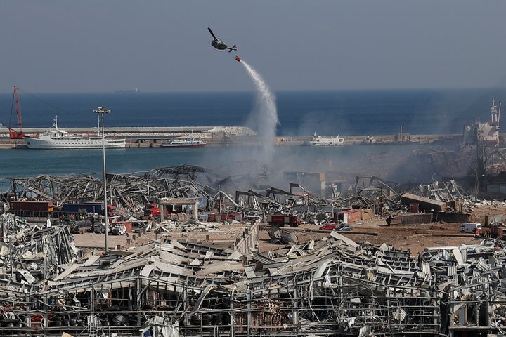 An army helicopter drops water at the scene of Tuesday's massive explosion that hit the seaport of Beirut, Lebanon, Wednesday, Aug. 5, 2020. (AP Photo/Hussein Malla)