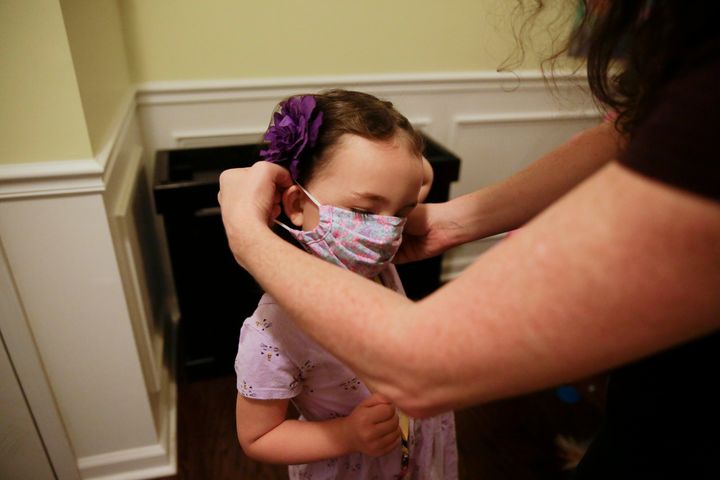 Η 5χρονη Ρέιτσελ Ανταμους φορά τη μάσκα της με τη βοήθεια της μητέρας της πριν πάει στο νηπιαγωγείο (Ντάλας, Τέξας- 3 Αυγούστου) 