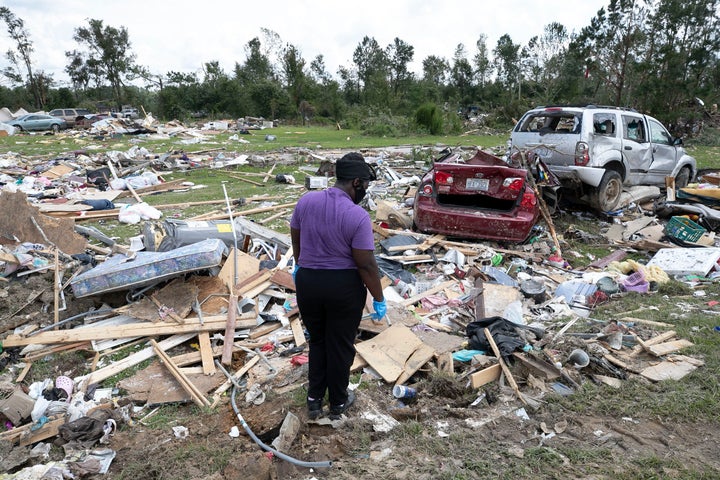 Cynthia Cooper looks for personal items for a family member who had their home destroyed after a tornado spawned by Hurricane Isaias destroyed a rural mobile home neighborhood, killing two residents, near Windsor N.C. on Wednesday.