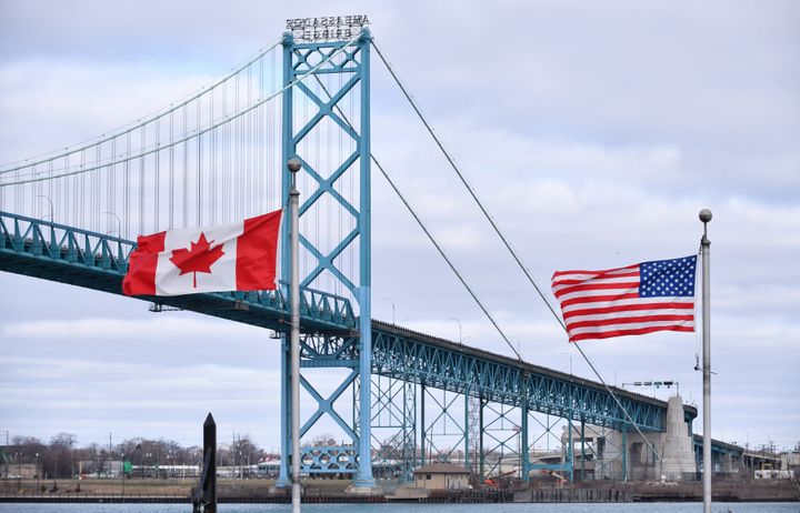 Canadian and American flags fly near the Ambassador Bridge at the Canada-U.S. border crossing in Windsor, Ont. on March 21, 2020. country.