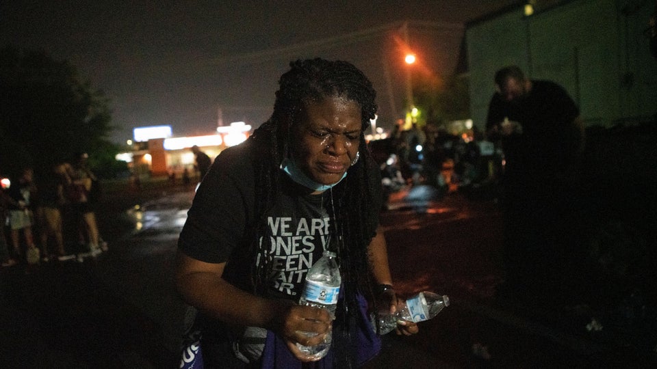 Cori Bush uses water to rinse her face after being tear-gassed by police in Florissant, Missouri, on...