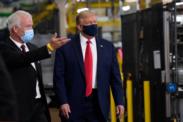 U.S. President Donald Trump wears a mask as he gets a tour from Whirlpool's Jim Keppler during a tour of the company's facility in Clyde, Ohio, on Thursday.