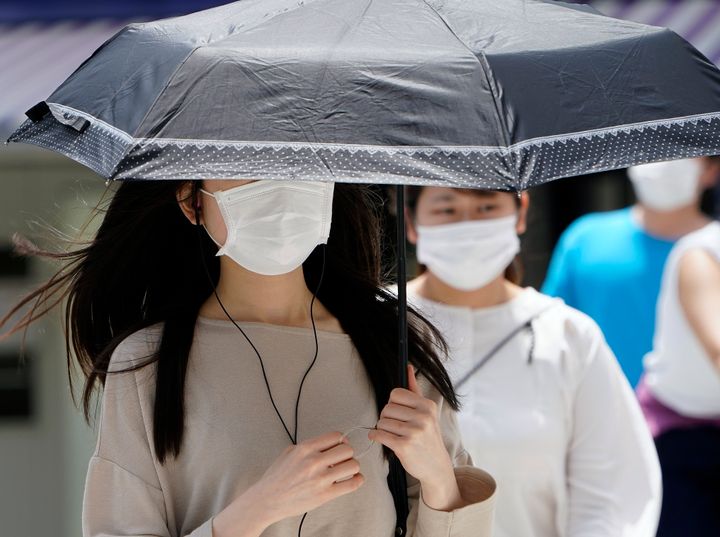 日傘を差して歩くマスクをした女性（=2020年05月25日撮影）