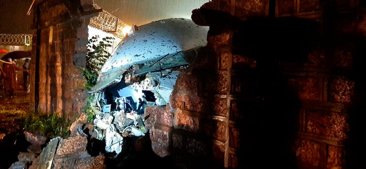 A part of the Air India Express flight is seen through a broken wall after it skidded off a runway while landing at the airport in Kozhikode, Kerala state, India, Friday, Aug. 7, 2020. (AP Photo)