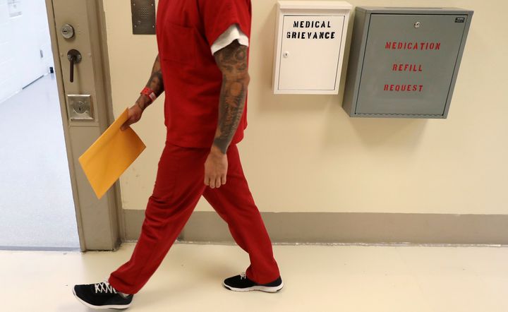 A detainee walks past boxes to file medical grievances during a 2019 media tour of an ICE detention center in Tacoma, Washington.