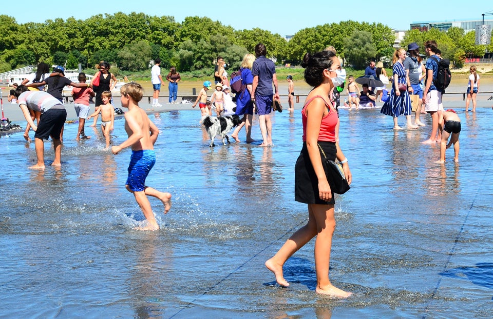 People cool off walking on the 'miroir d'eau' ('water mirror') in Bordeaux, southwestern France.