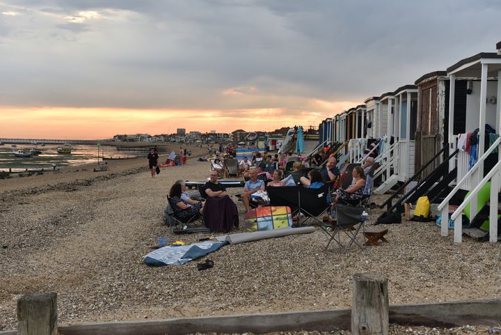 People sit on the beach into the evening as the sun set on Saturday in Southend-on-Sea.