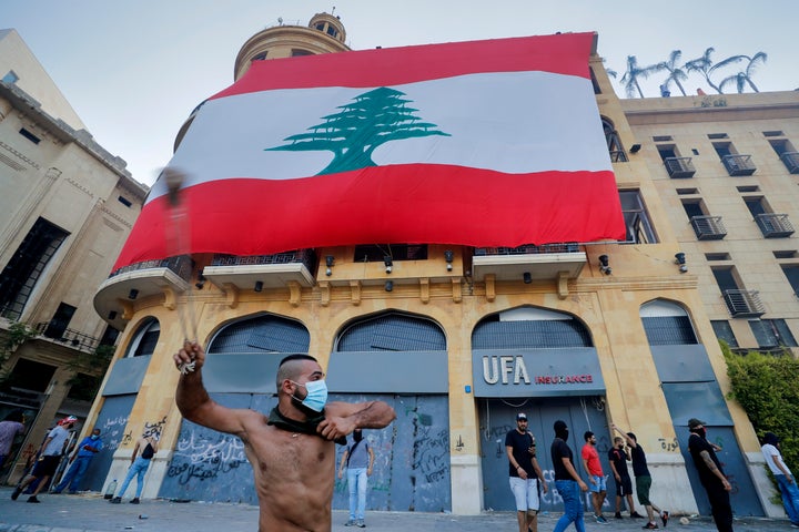People clash with police during a protest against the political elites and the government after this week's deadly explosion