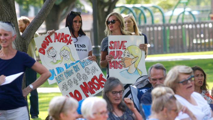 Stephanie Grant, left, and Tiffany Barker joins others during an anti-mask rally Wednesday, Aug. 5, 2020, in Orem, Utah. (AP Photo/Rick Bowmer)